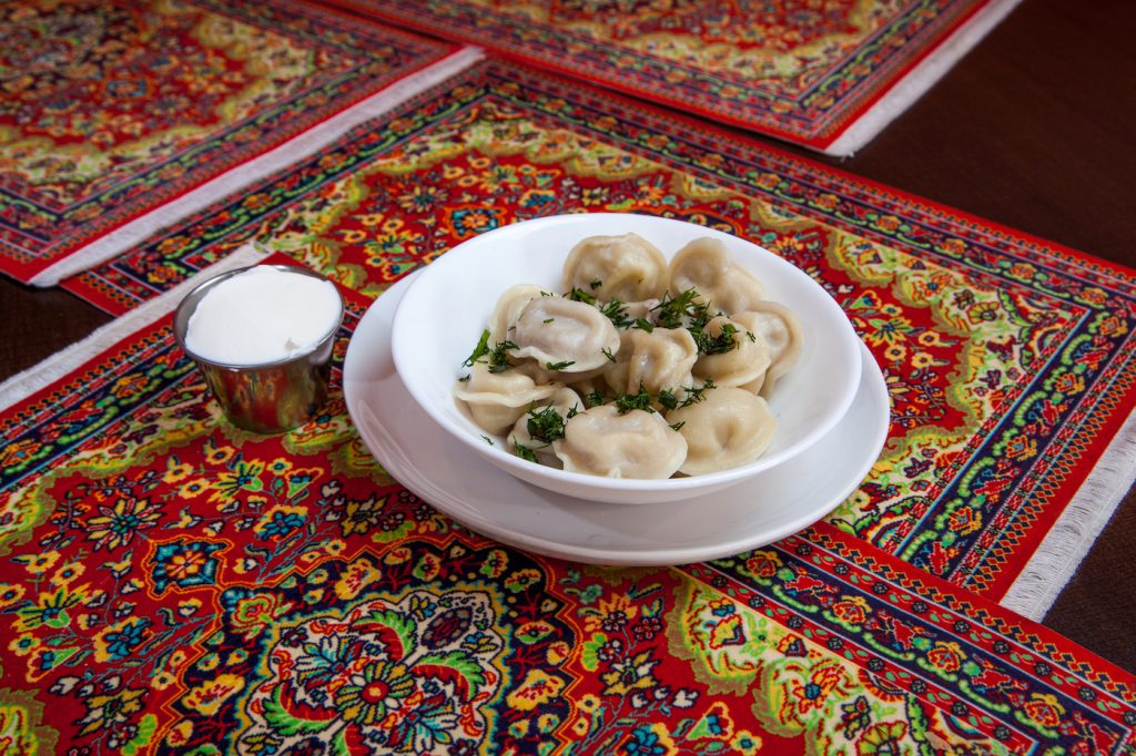 A plate of pelmini on intricately designed rugs