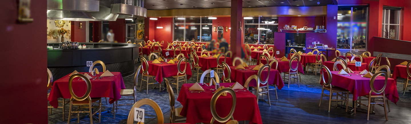 The dining room of Caspian Grill's Junction Road location. A red-focused color scheme is classy but also welcoming, and is not stuffy or uncomfortably fancy.